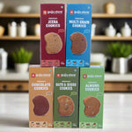 A combo pack of Gujju Store's premium cookies featuring five boxed flavors: Jeera, Multigrain, Chocolate, Oats & Seeds, and Almond. Each box is 150g and labeled with “No Maida, No Sugar.”