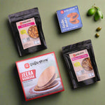 A collection of five Gujju Store snack products arranged on a white background. The items include a red and white box of Jeera Khakhra, a blue box of Garlic Bhakhri, a black pouch of Oats Chips, a black pouch of Multimillet Chips, and all products are attractively packaged with bold branding and clear labeling.